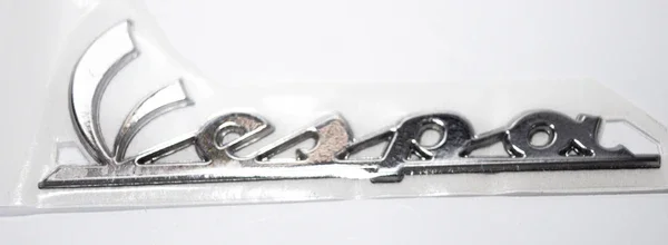 656219 - TARGHETTA "VESPA" FRONTALE ORIGINALE PER VESPA LX 125-150/PX 2011 LATERALE Popolare